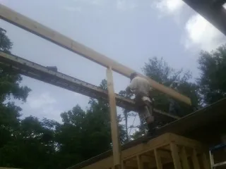 Carpenter setting a ridge beam over a new addition frame — Ice Dam Removal by Roofing Brothers in Avon Lake