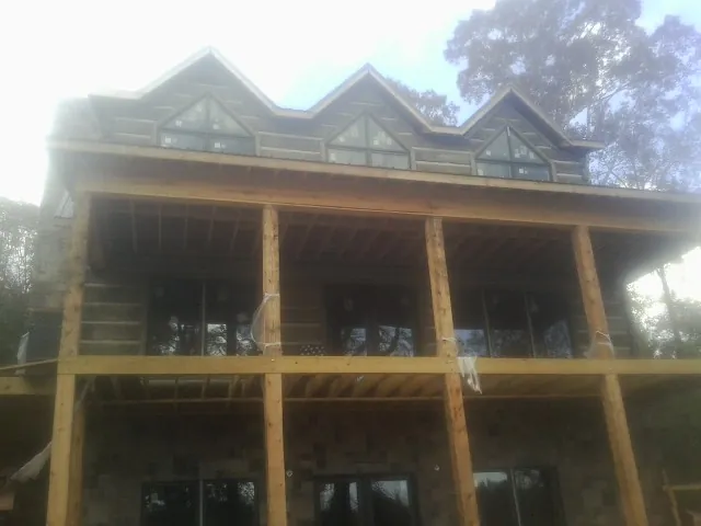 Dormers and porch framing on a large log home under construction — Roof Coating work by our crew in Avon Lake