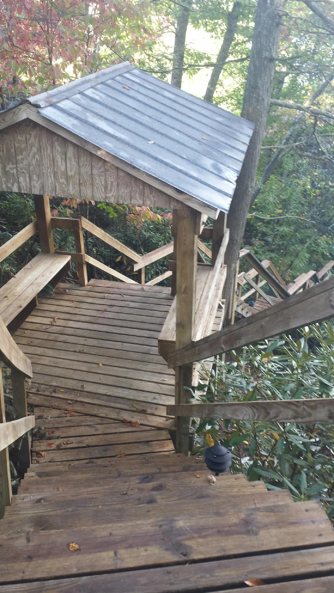 Metal roofed shelter over wooden steps on a wooded walkway — Skylight Repair & Installation work by our crew in Avon Lake