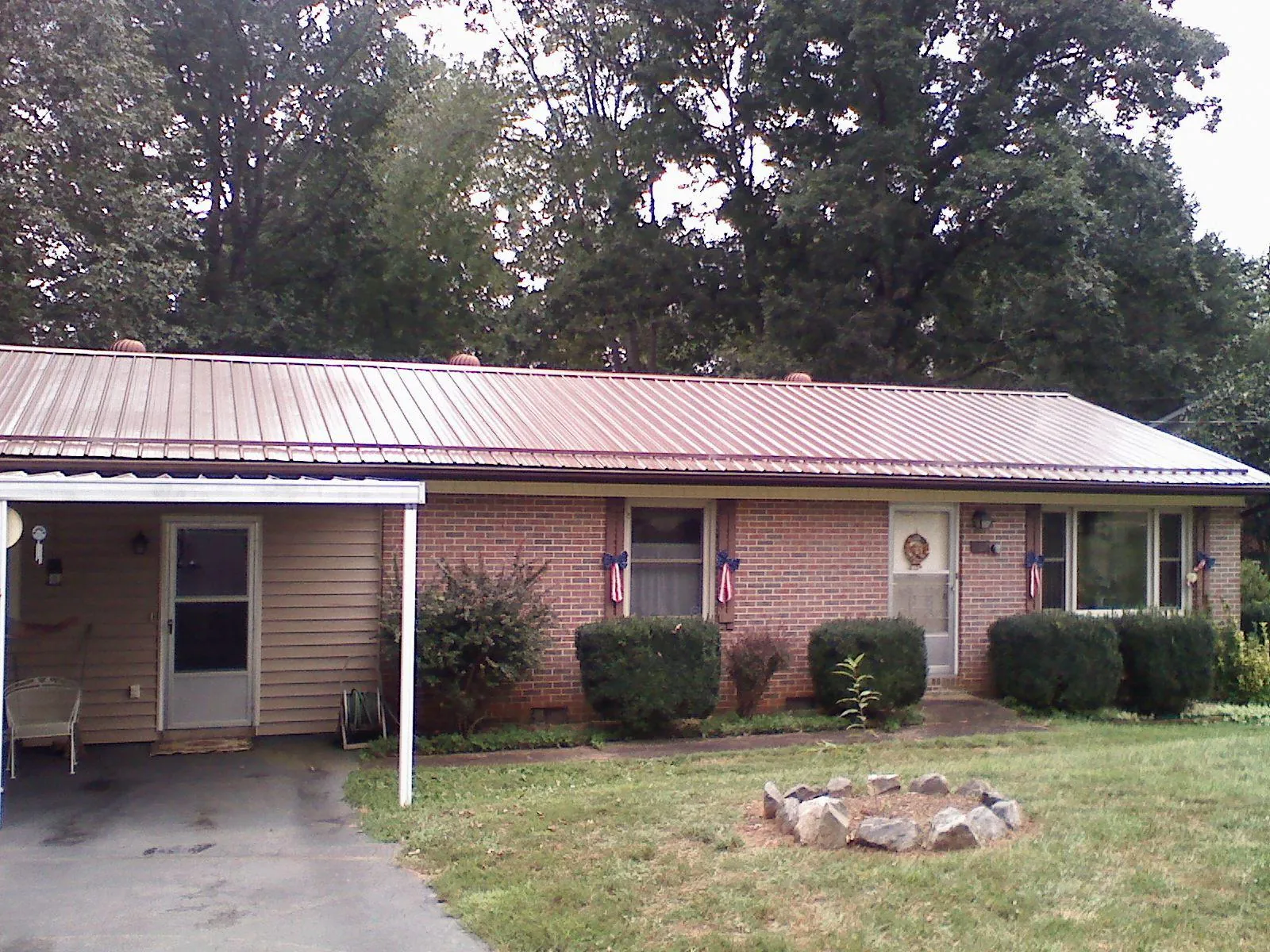 Bronze metal roof and carport on a brick ranch home — Roof Repair work by our crew in Avon Lake